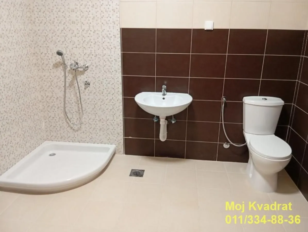Bathroom equipped with a shower cabin, washbasin, and toilet.