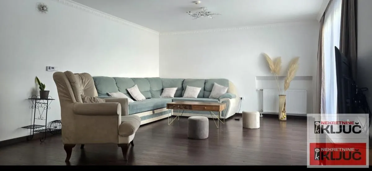 Spacious living room with a corner sofa and an armchair.