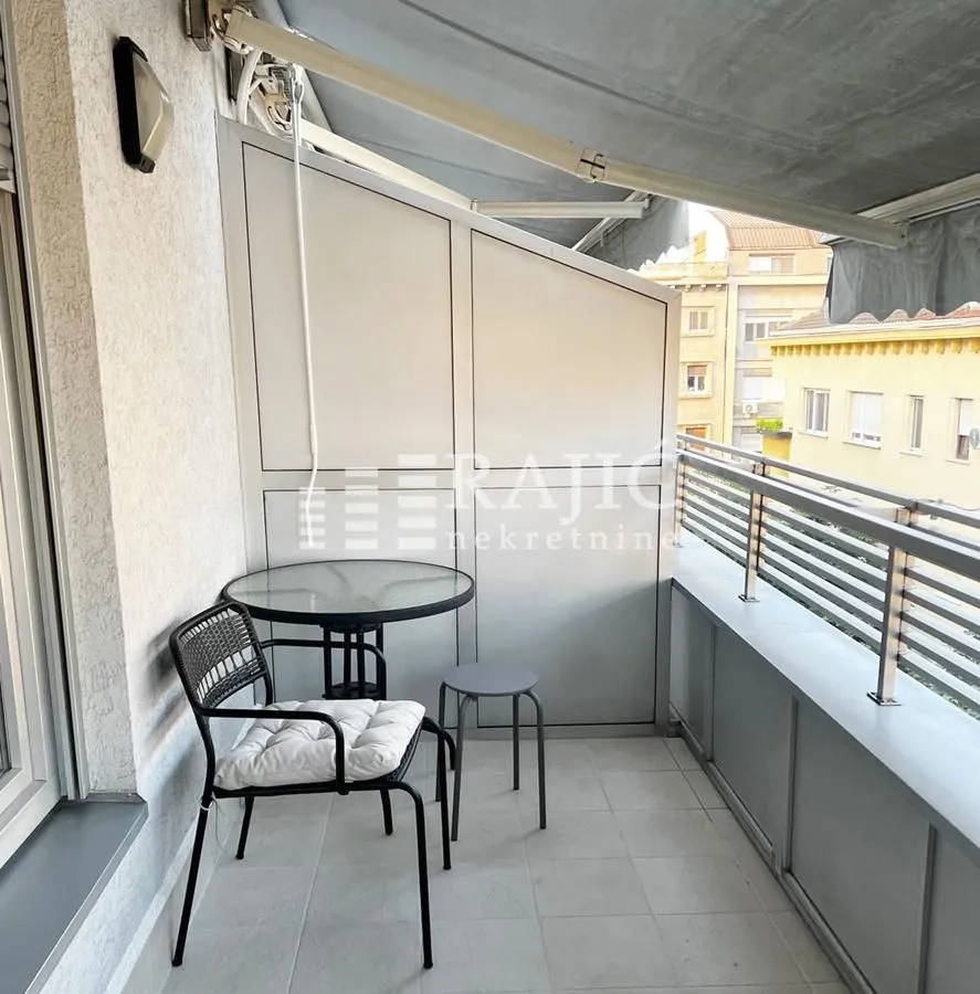 Furnished terrace with a table, chairs, and protective awning.