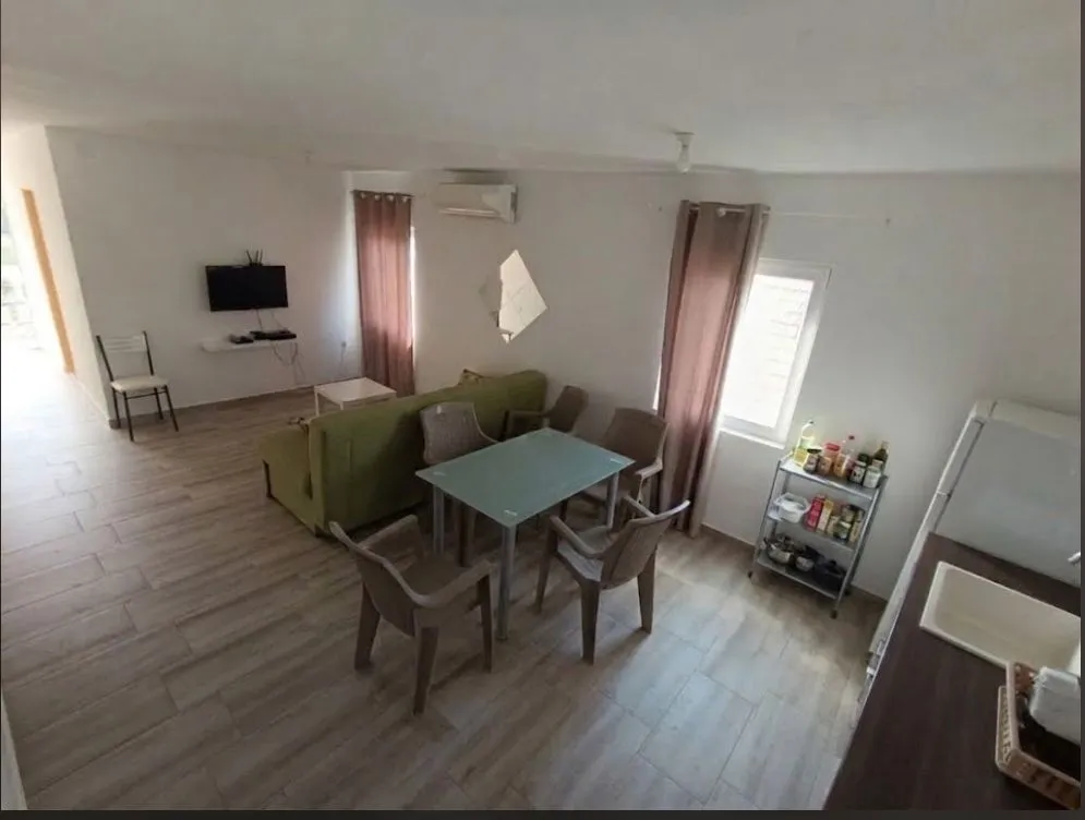 Spacious living room combined with a dining area and a kitchen corner.