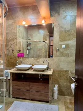 Modern bathroom with dual sinks and stone-patterned ceramic tiles. - image 9