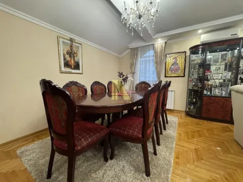 Trpezarija sa velikim drvenim stolom i stolicama u stanu. - image 4