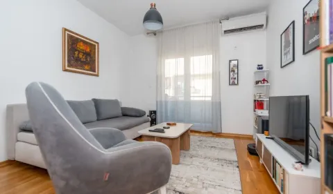 Living room with a sofa, armchair, and television. - image 2