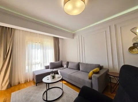 Dnevna soba sa ugaonom garniturom, stočićem i velikim prozorom. - image 4