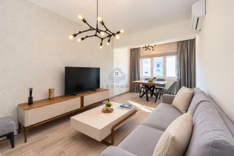 Spacious living room with sofa, TV, and dining area in the background. - image 2