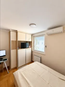 Small bedroom with a bed, wardrobe, and desk. - image 13