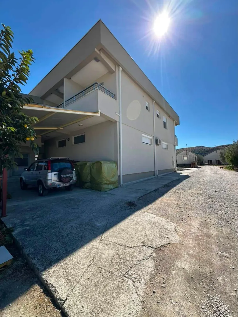 Exterior of the house with yard and parking.
