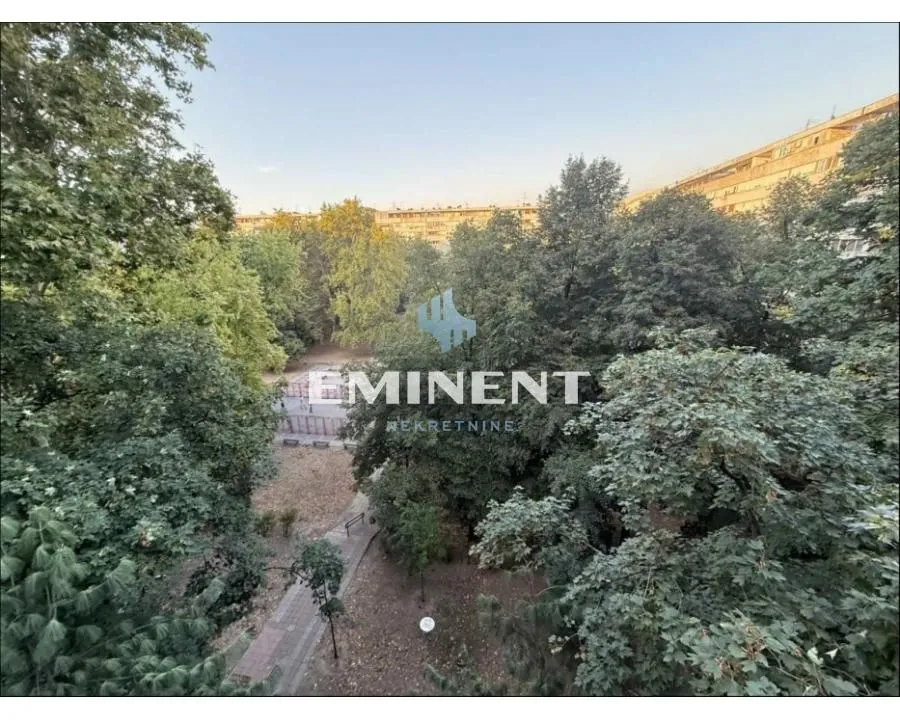 Window view overlooking a green park and surrounding residential buildings.