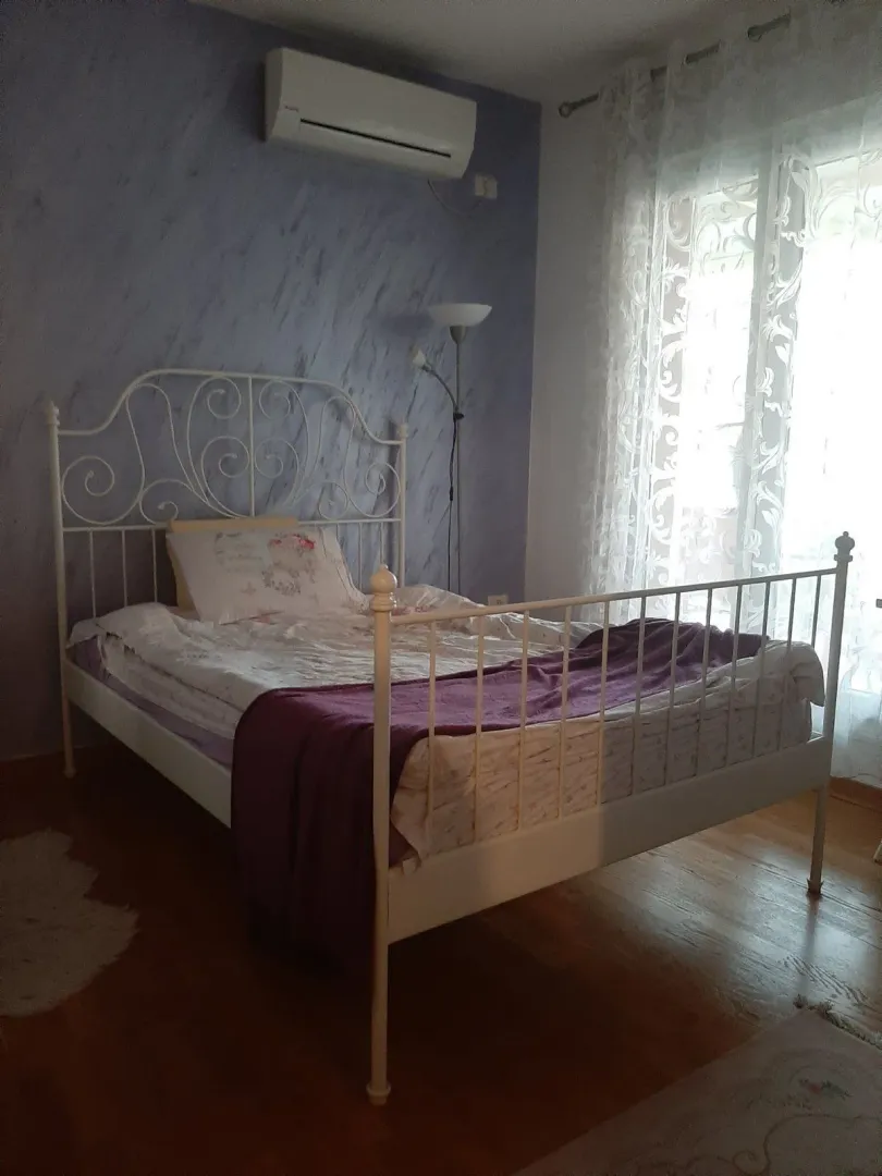 Bright bedroom with a white metal bed.
