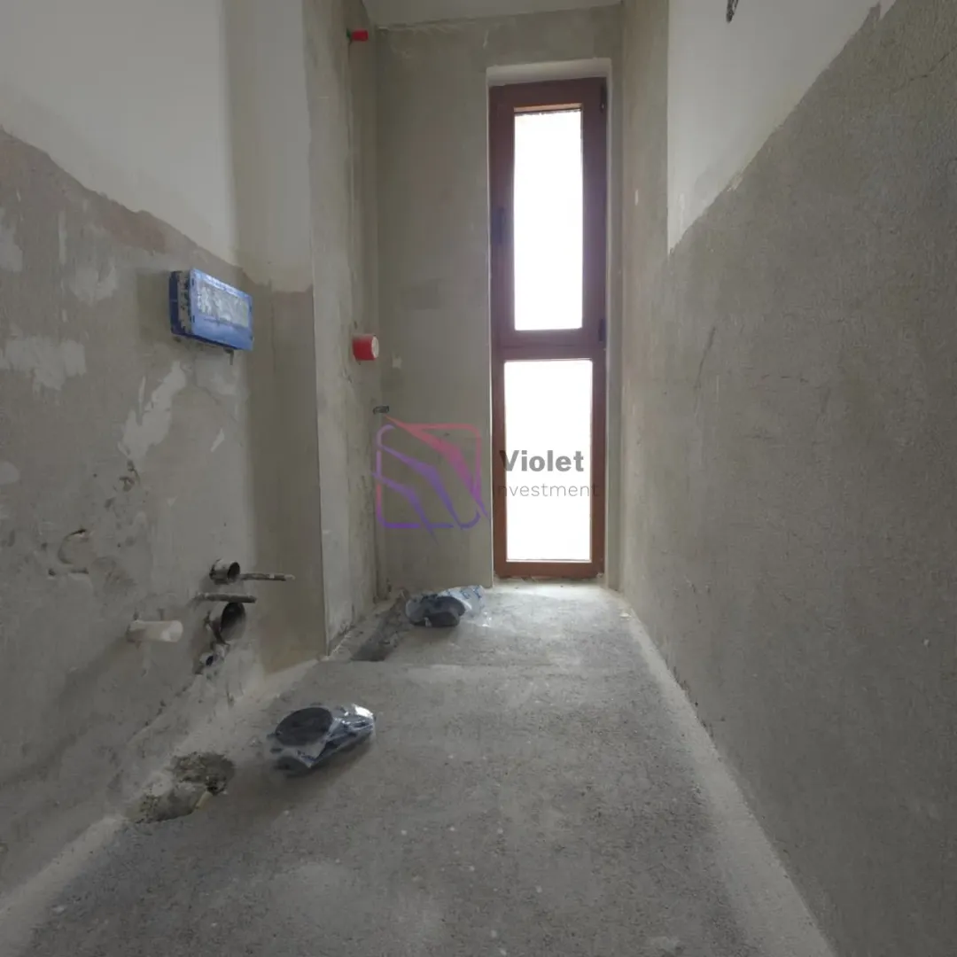Pogled na prostoriju u fazi grubih radova sa instalacijama i prozorom.