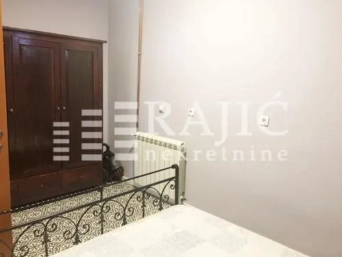 Furnished bedroom with a wooden wardrobe and a bed.