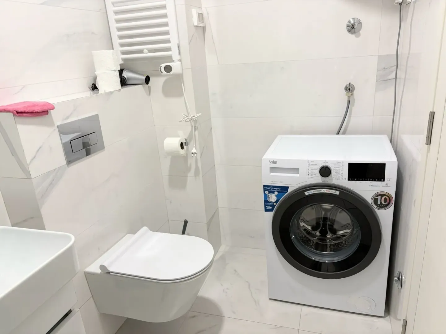 Svijetlo i moderno kupatilo sa veš mašinom.