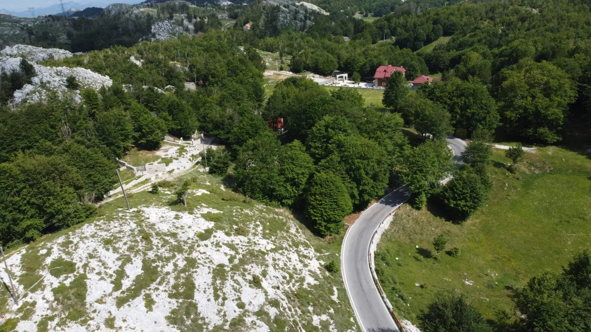 Pogled iz vazduha na okolno prirodno okruženje i put koji vodi do imanja.