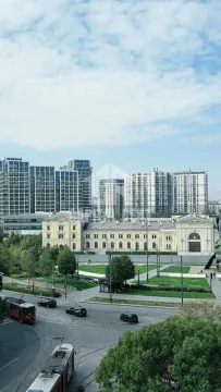 Pogled sa prozora na gradski trg, saobraćajnicu i moderne zgrade u pozadini. - image 12