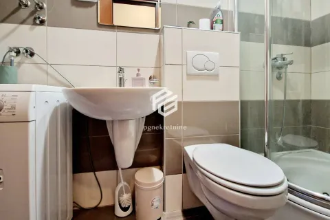 Kupatilo opremljeno umivaonikom, WC šoljom, tuš kabinom i veš mašinom. - image 3