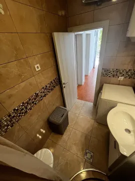 Kupatilo sa keramičkim pločicama, umivaonikom i veš mašinom. - image 14
