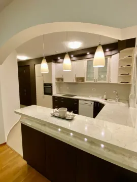 Modern kitchen with a breakfast bar and hanging cabinets. - image 5