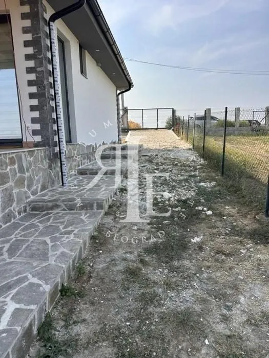 View of the exterior part of the house with stone paving and yard.