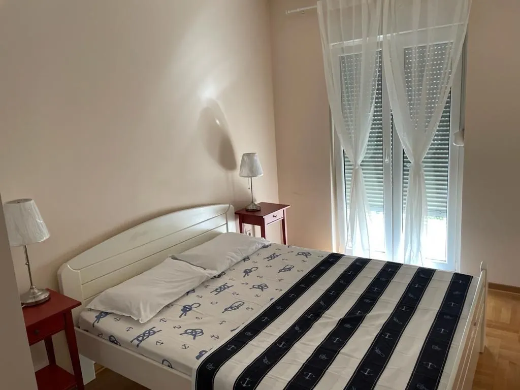 A bright bedroom with a double bed and nightstands.
