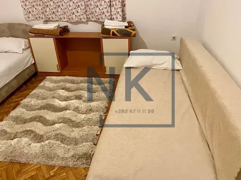 Namještena spavaća soba sa dva kreveta i tepihom. - image 5