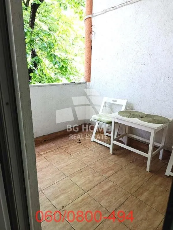 Small covered balcony with a table and chairs.