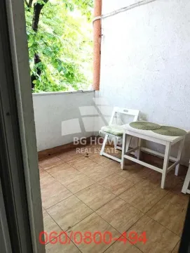 Small covered balcony with a table and chairs. - image 8