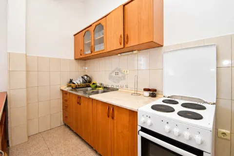 Small kitchen with wooden cabinetry and a freestanding stove. - image 15