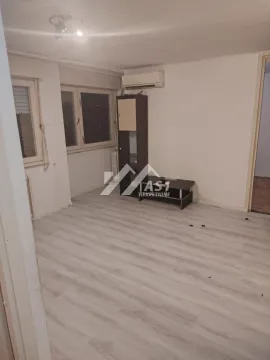Prazna dnevna soba sa svetlim laminatom, klima uređajem i komadom nameštaja. - image 6