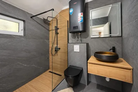 Moderne kupatilo sa tuš kabinom, crnim sanitarijama i drvenim detaljima. - image 5