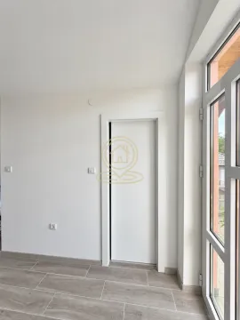 An empty room with white walls, an interior door, and large glass doors. - image 5