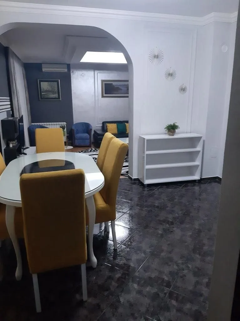 Living room with a dining table and yellow chairs.