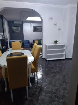 Living room with a dining table and yellow chairs. - image 9
