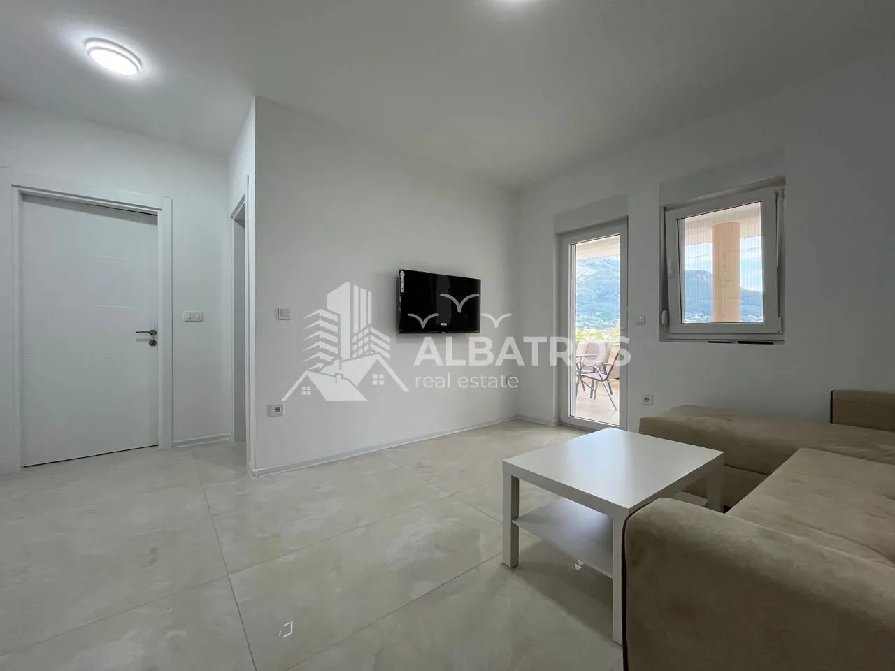 Living room with a sofa and wall-mounted television.