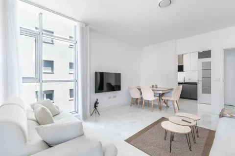 Bright and modernly furnished living room with a dining area and large windows. - image 10