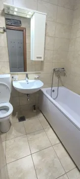 A functional bathroom with a bathtub and a mirror. - image 27