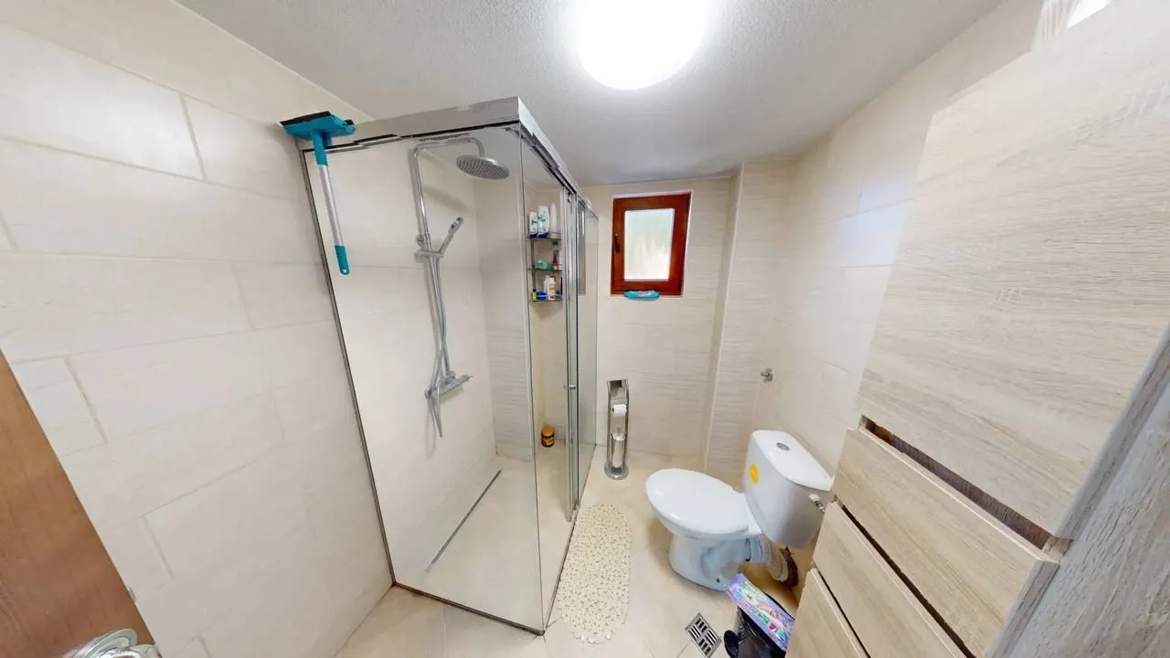 Manje kupatilo sa tuš kabinom i WC šoljom.