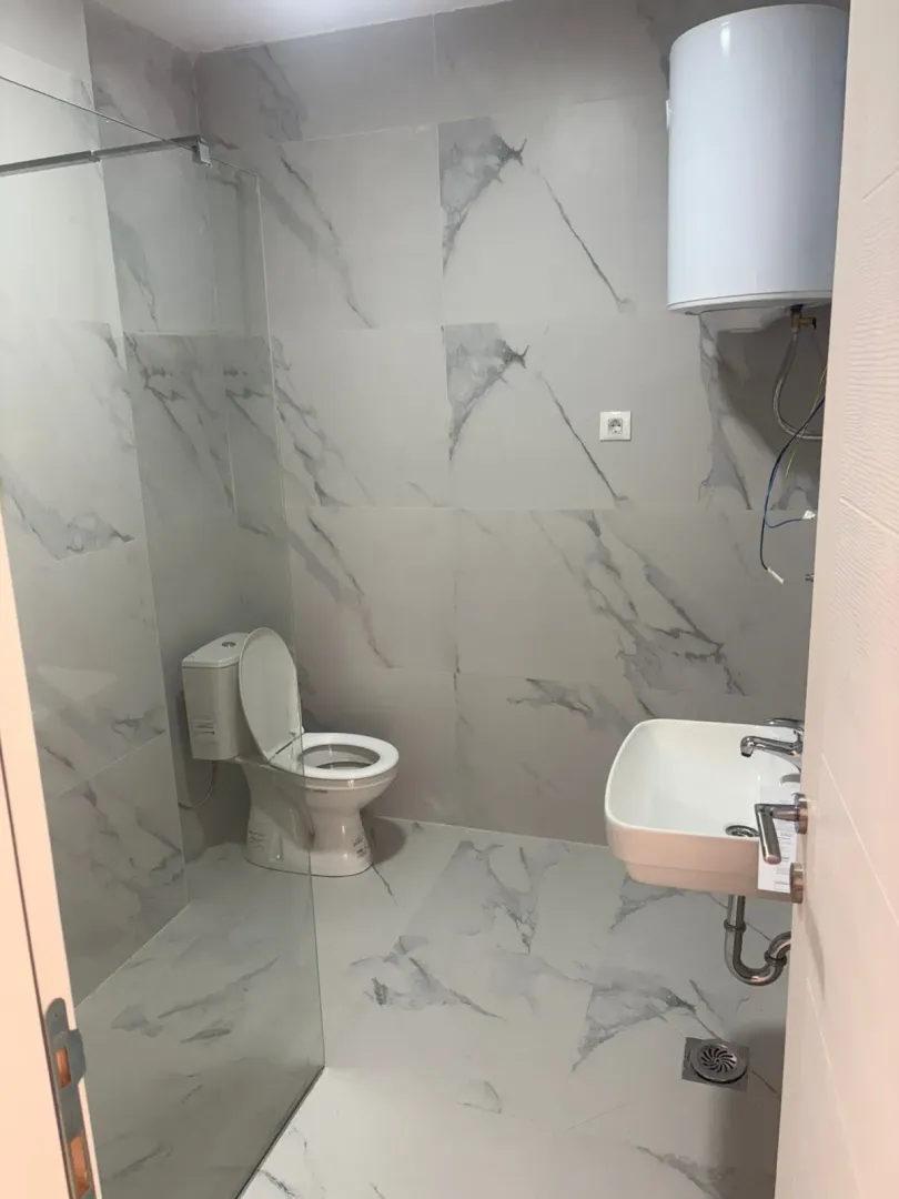 Kupatilo opremljeno tuš kabinom, WC šoljom, umivaonikom i bojlerom.