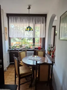 Trpezarija sa okruglim drvenim stolom i četiri stolice pored prozora. - image 4