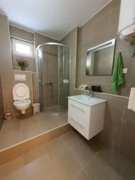 Kupatilo opremljeno tuš kabinom, umivaonikom i WC šoljom. - image 6