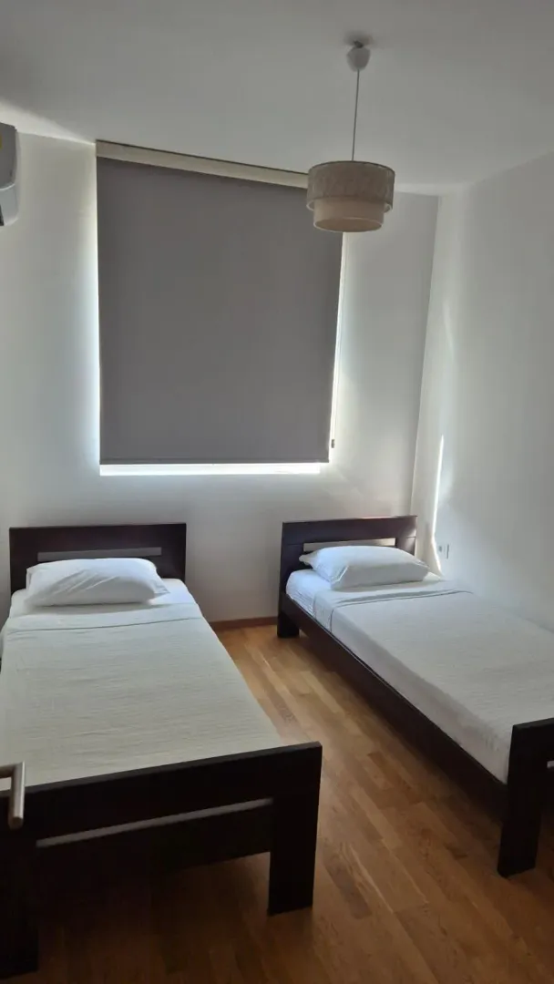 Bedroom with two single beds and parquet flooring.