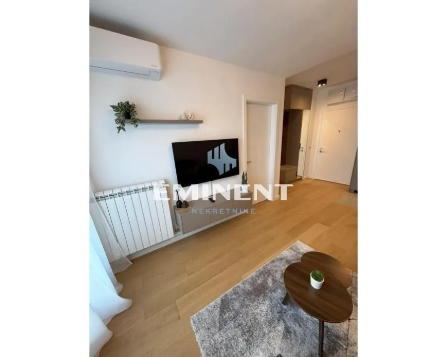 Living room with television, air conditioning and parquet flooring.
