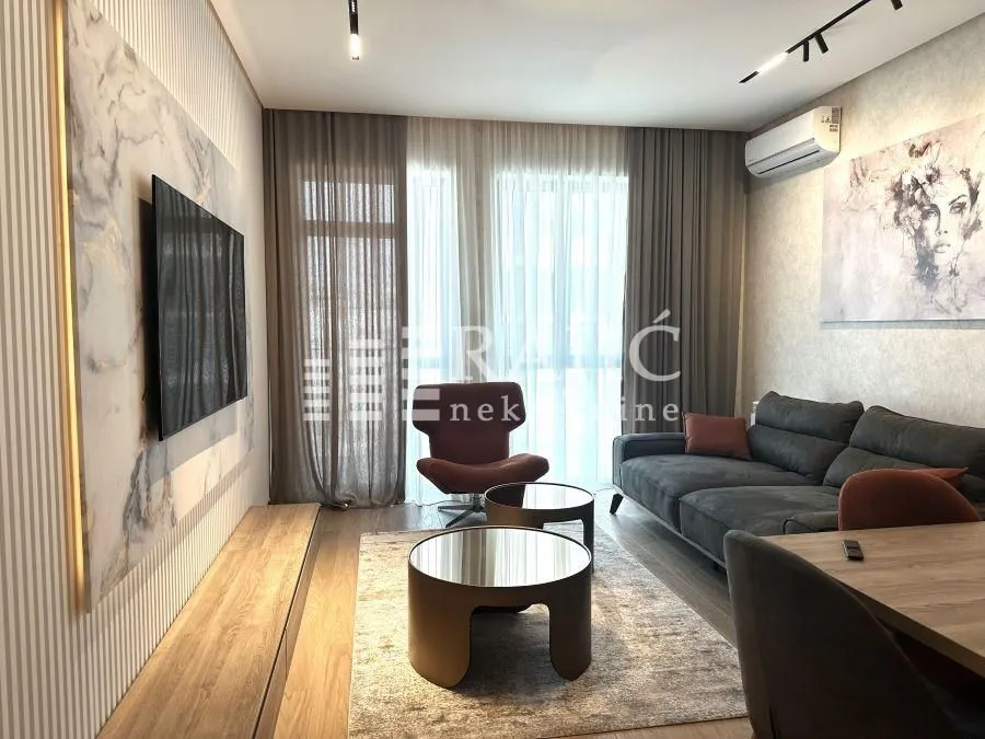 Modern living room with a sofa, TV, and dining table.