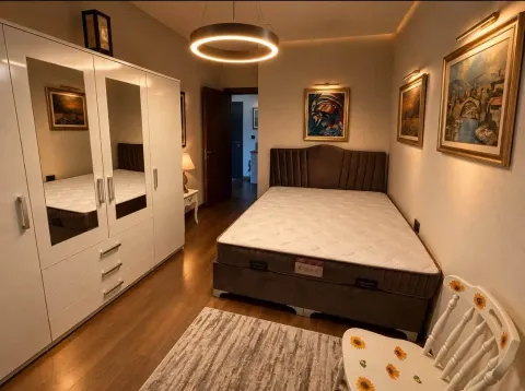 Uređena spavaća soba sa bračnim krevetom, velikim garderoberom sa ogledalima i umjetničkim slikama na zidu. - image 5
