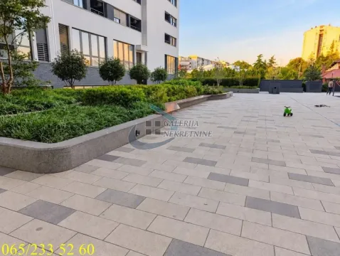 Popločano dvorište sa uređenim zelenilom ispred stambene zgrade. - image 19