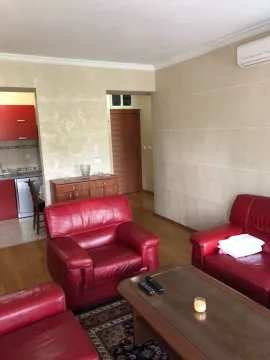 Living room with red leather furniture and a view of the kitchen. - image 3