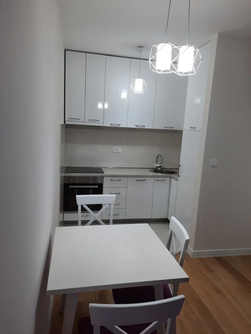 Bright kitchen with white cabinets and a dining table.