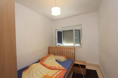 Mala spavaća soba sa jednim krevetom, noćnim ormarićem i otvorenim prozorom. - image 20