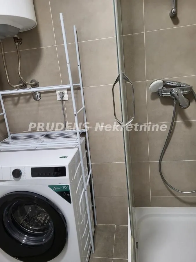 Kupatilo sa tuš kabinom i veš mašinom.