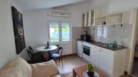 Compact kitchen with a dining table and a living area. - image 6