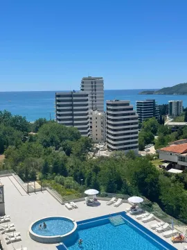 View from the terrace overlooking the pool, buildings, and the sea. - image 3